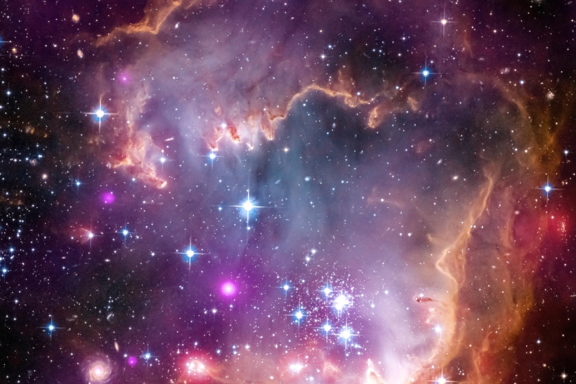 This image obtained from NASA on April 4, 2013 shows the tip of the "wing" of the Small Magellanic Cloud galaxy in this new view from NASA's Great Observatories. The Small Magellanic Cloud, or SMC, is a small galaxy about 200,000 light-years way that orbits our own Milky Way spiral galaxy.The colors represent wavelengths of light across a broad spectrum. X-rays from NASA's Chandra X-ray Observatory are shown in purple; visible-light from NASA's Hubble Space Telescope is colored red, green and blue; and infrared observations from NASA's Spitzer Space Telescope are also represented in red. The spiral galaxy seen in the lower corner is actually behind this nebula. Other distant galaxies located hundreds of millions of light-years or more away can be seen sprinkled around the edge of the image.The SMC is one of the Milky Way's closest galactic neighbors. Even though it is a small, or so-called dwarf galaxy, the SMC is so bright that it is visible to the unaided eye from the Southern Hemisphere and near the equator. Many navigators, including Ferdinand Magellan who lends his name to the SMC, used it to help find their way across the oceans. = RESTRICTED TO EDITORIAL USE - MANDATORY CREDIT " AFP PHOTO / NASA/CXC/JPL-Caltech/STScI " - NO MARKETING NO ADVERTISING CAMPAIGNS - DISTRIBUTED AS A SERVICE TO CLIENTS=HO/AFP/Getty Images